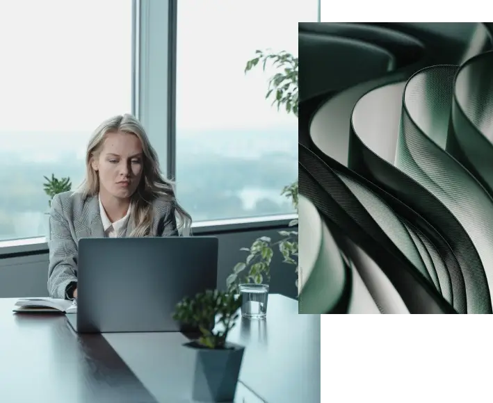 1. A person in a suit typing on a laptop in a high office with several plants around the space. 2. Abstract image of curving grey lines.