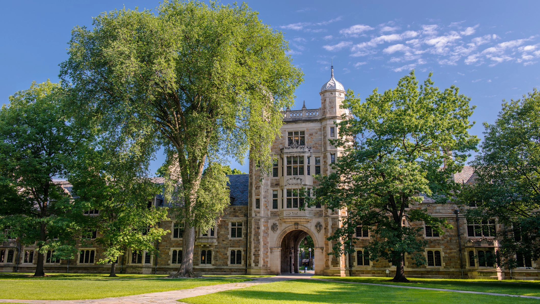 A large historic building surrounded by trees and greenery.
