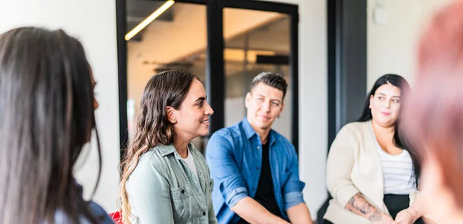 A group of people having a conversation in a meeting room.
