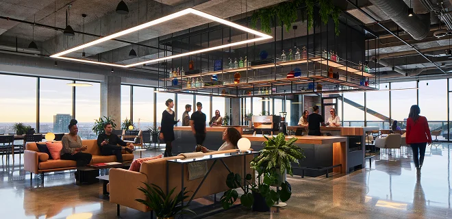 A lofty lounge with a bar in the center and couches to the left.