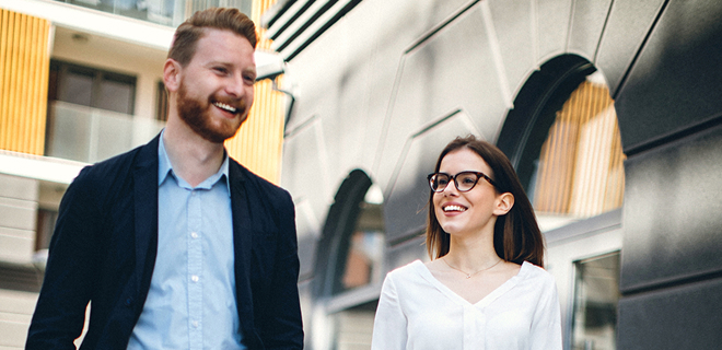 L’image montre deux personnes qui marchent ensemble à l’extérieur.