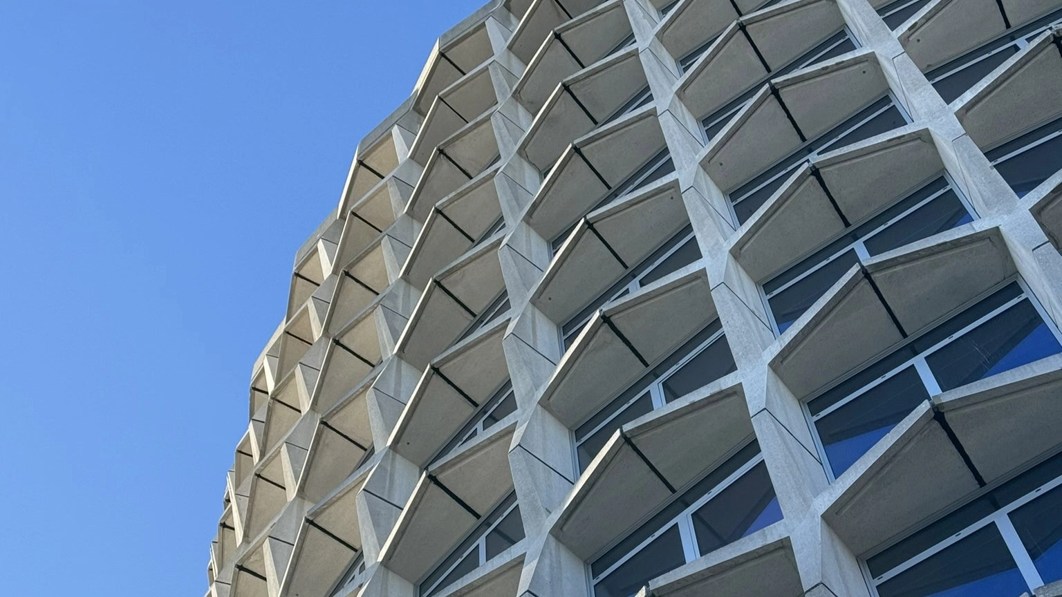 L’extérieur d’un bâtiment moderne contre un ciel bleu.