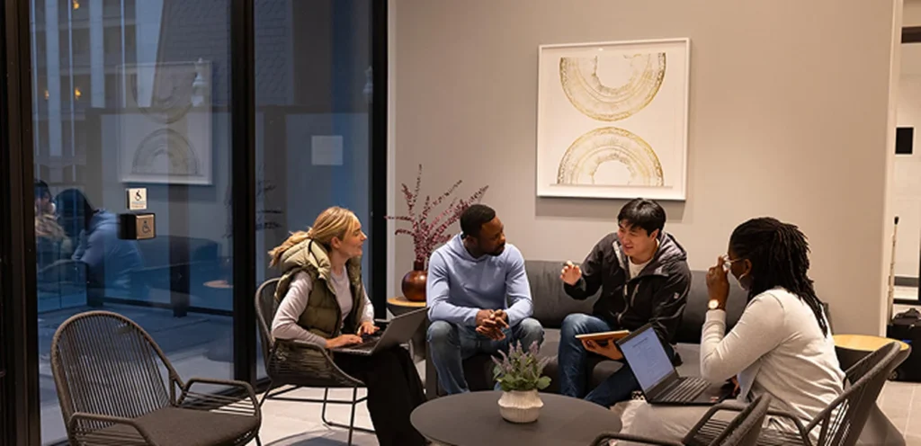 Un groupe de personnes s’assoient et discutent dans un cadre intérieur moderne à décor contemporain.