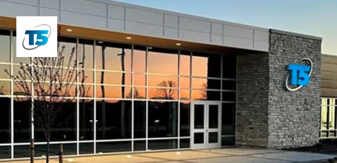A modern building with large reflective glass windows and a stone facade.