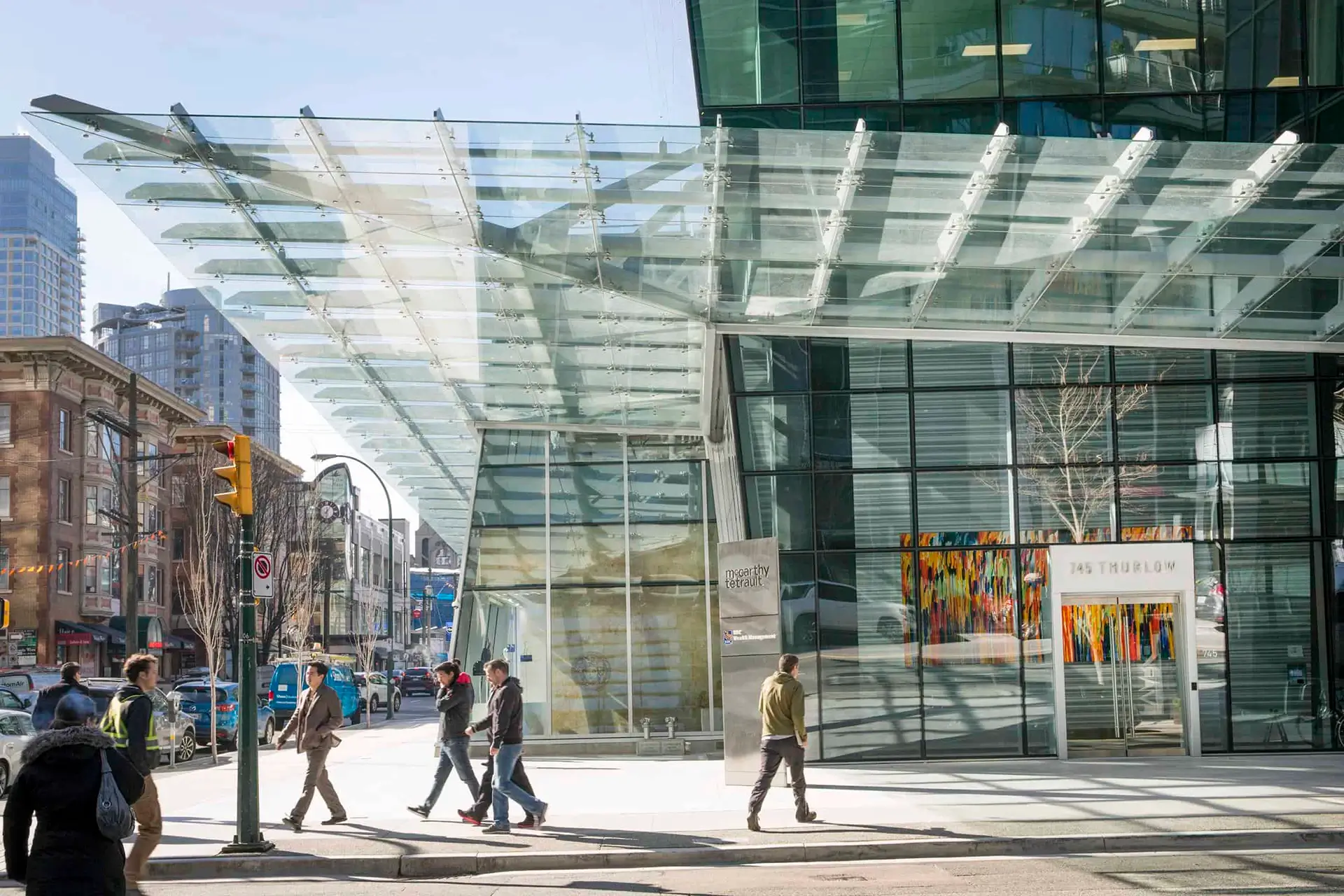 An outdoor scene with people and a modern glass building.