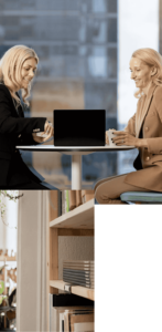 1. Two people reviewing a laptop on desk in a office. 2.A view of books on a shelf in an office setting.