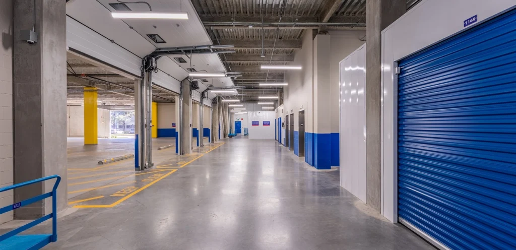 Interior view of a storage facility with blue storage units to the right.