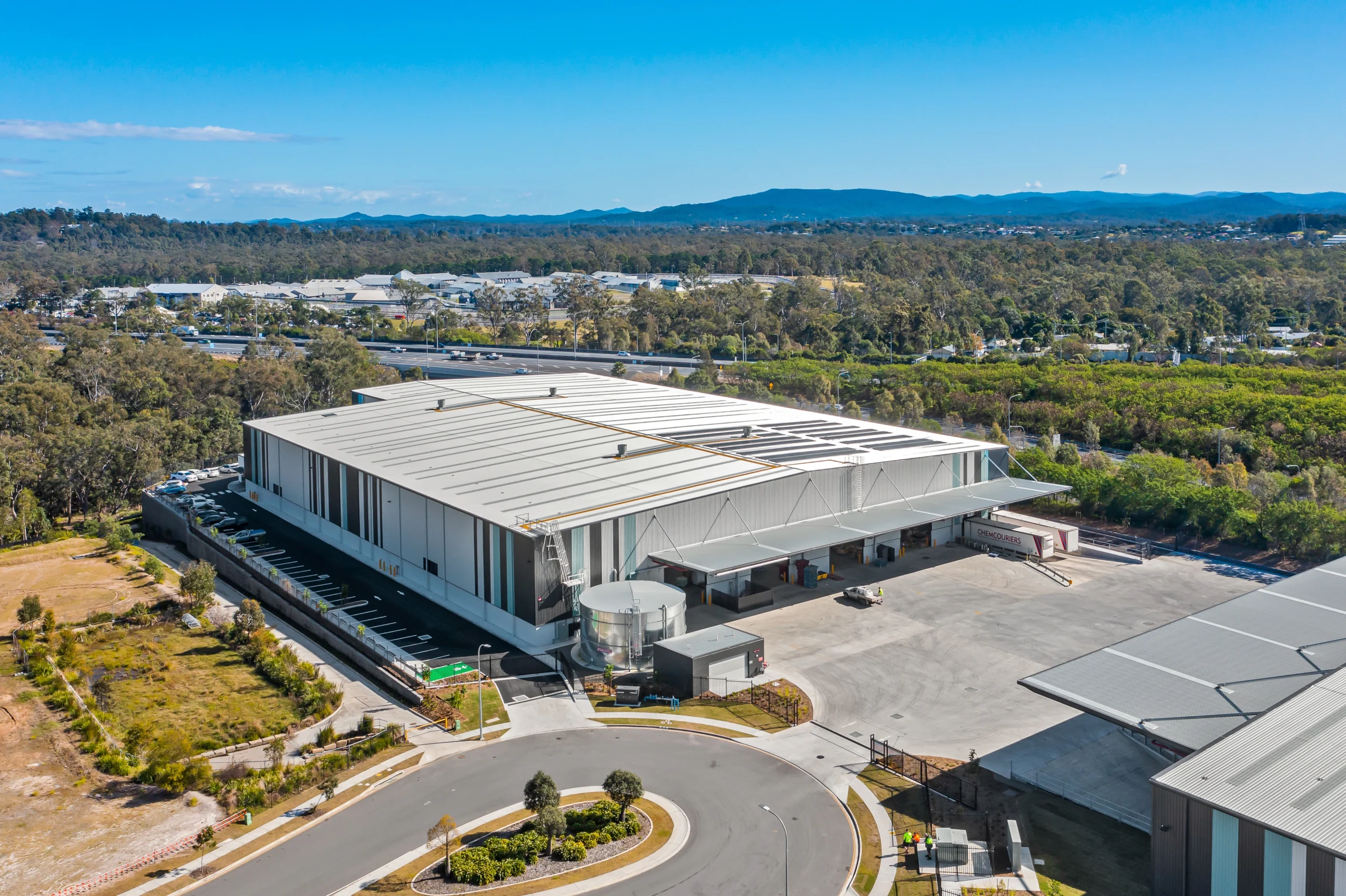 Aerial view of a large industrial building on a sunny day.