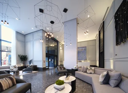 Un salon élégant et moderne avec sofas confortables, luminaires élégants et décor contemporain. La salle est dotée d’une atmosphère sophistiquée et aérée.