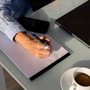 Une personne écrit des notes sur un bloc de papier.