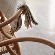 Un tissu drapé élégamment sur le dossier d’une chaise en bois.